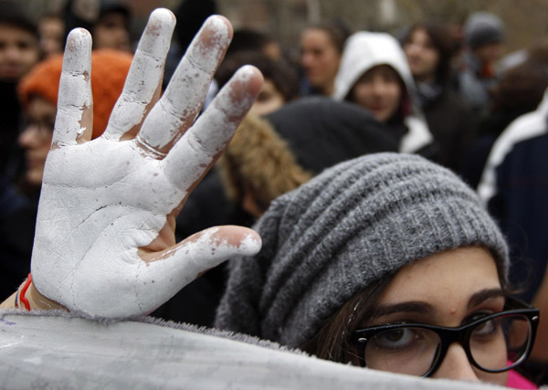 A student shows a hand painted in white during a demonstration in Rome Dec 22, 2010. [China Daily/Agencies]