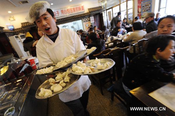 A waiter serves dumplings for customers at a restaurant in Beijing, capital of China, Dec. 22, 2010, also the day of Dongzhi, the traditional Chinese winter solstice festival. People in north China have a tradition of eating dumplings on the festival to protect their ears from frostbite. [Xinhua] 