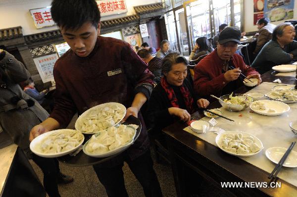 A waiter serves dumplings for customers at a restaurant in Beijing, capital of China, Dec. 22, 2010, also the day of Dongzhi, the traditional Chinese winter solstice festival. People in north China have a tradition of eating dumplings on the festival to protect their ears from frostbite. [Xinhua] 