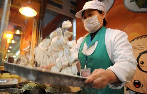 Dumplings are made by staff members at a supermarket in Yinchuan, capital of Northwest China’s Ningxia Hui autonomous region, Dec 21, 2010. [Xinhua]