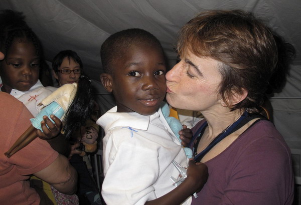 A French woman kisses a Haitian child to be adopted in Port-au-Prince December 21, 2010. At least 318 Haitian children are to be adopted by French families, some of whom have already flown into Haiti on Tuesday on flights chartered by authorities. [China Daily/Agencies] 