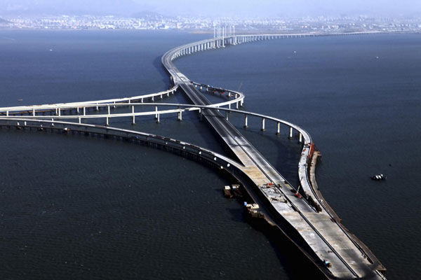 Photo taken on Dec 8 shows an aerial view of the Qingdao Haiwan Bridge under construction. The main section of the bridge was joined up on Dec 22. [Xinhua]