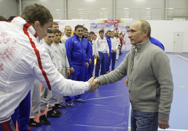 Russia's Prime Minister Vladimir Putin (R) shakes hands with wrestlers as he visits the 'Moscow' sports complex in St. Petersburg, December 22, 2010. [China Daily/Agencies]