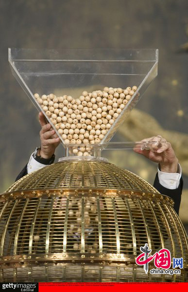 An operator of the National Organization of Lotteries and Gambling fills the hype with lottery balls at Palacio de Congresos on December 22, 2010 in Madrid, Spain. This year&apos;s prize pot for Spain&apos;s traditional Christmas lottery &apos;El Gordo&apos; rose to 2.3 billion euros, with winners holding tickets numbered 79250 receiving a first prize of 300,000 euros. [CFP]