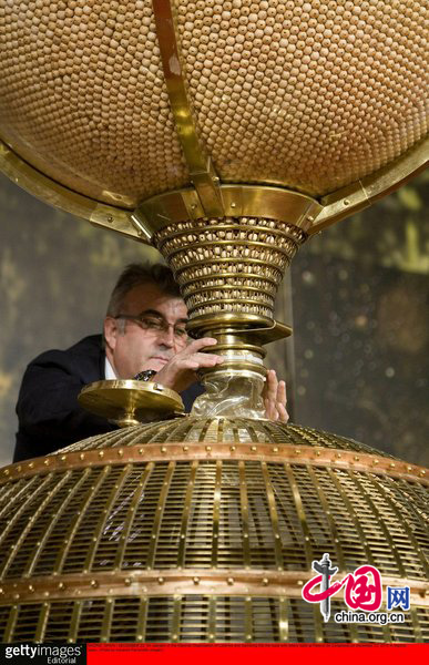 An operator of the National Organization of Lotteries and Gambling fills the hype with lottery balls at Palacio de Congresos on December 22, 2010 in Madrid, Spain. This year&apos;s prize pot for Spain&apos;s traditional Christmas lottery &apos;El Gordo&apos; rose to 2.3 billion euros, with winners holding tickets numbered 79250 receiving a first prize of 300,000 euros. [CFP]