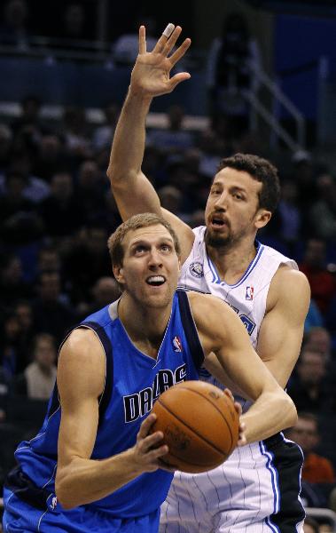 Dallas Mavericks forward Dirk Nowitzki (L) goes to shoot as he is defended by Orlando Magic forward Hedo Turkoglu (R) during first half NBA basketball action in Orlando, Florida December 21, 2010. The Mavericks beat the Magic 105 - 99. (Xinhua/Reuters Photo)