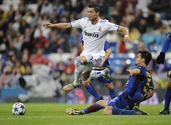 Real Madrid's Cristiano Ronaldo (C) fights for the ball with Levante's Miquel Robuste during their Spanish King's Cup soccer match at Santiago Bernabeu stadium in Madrid December 22, 2010. (Xinhua/Reuters Photo)