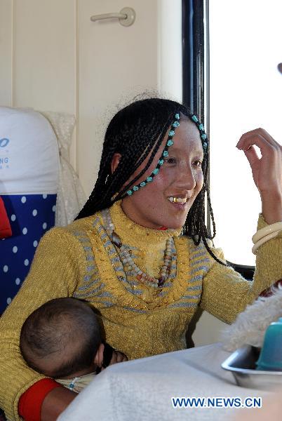 A woman holds her baby during her train journey to Lhasa in southwest China&apos;s Tibet Autonomous Region, Dec. 23, 2010.[Xinhua]