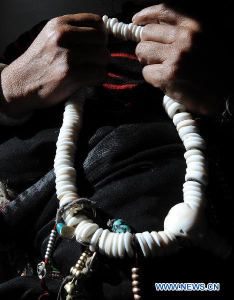 A woman holds prayer beads during her train journey to Lhasa in southwest China&apos;s Tibet Autonomous Region, Dec. 23, 2010. [Xinhua]