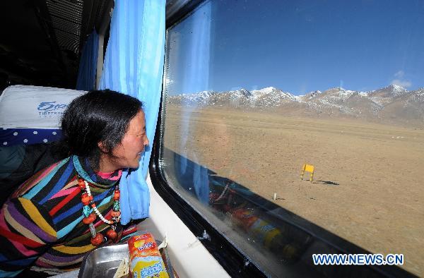 A woman looks out of the window during her train journey to Lhasa in southwest China&apos;s Tibet Autonomous Region, Dec. 23, 2010. [Xinhua]