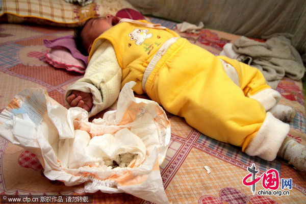 Photo takes on Dec 21, 2010 shows a baby sleeping near a used diaper in which five pieces of blades were found, in Nanzhuang county, South China's Guangdong province.