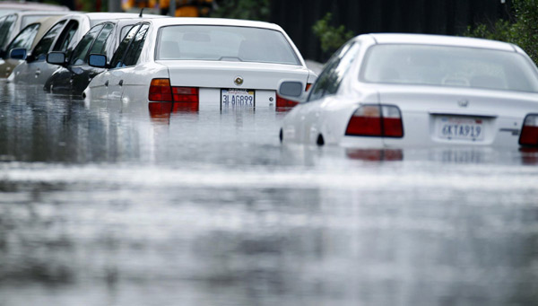 Cars parked on a city street are surrounded by flood waters after heavy rains caused flooding in San Diego, California Dec 22, 2010. [China Daily/Agencies] 