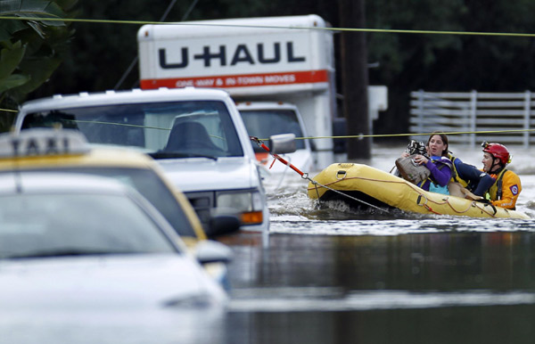 An emergency water rescue crew ferries hotel guests from their hotel after heavy rains and flooding trapped guests staying at a hotel in San Diego, California Dec 22, 2010. [China Daily/Agencies]