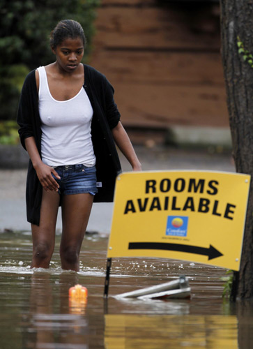 A women wades through waters after flooding forced her from her hotel in San Diego, California Dec 22, 2010. [China Daily/Agencies]