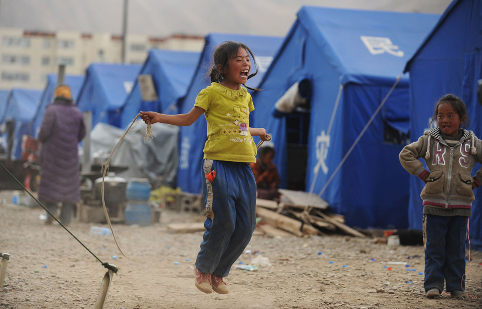 A girl plays near a tent in quake-hit area Yushu, Qinghai province, April 18, 2010. [Xinhua] 