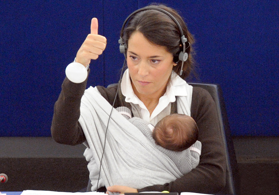 Italian Member of the European Parliament Licia Ronzulli takes part in a vote as she cradles her 1-month-old baby at the European Parliament in Strasbourg, France, September 22, 2010. She wanted to make a point about the difficulties women face in trying to juggle careers and child care. [Chinanews.com]