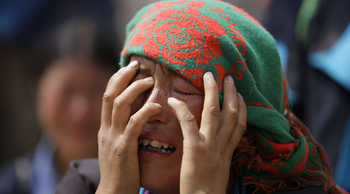 A woman cries before the debries of her house in the landslide-hit Zhouqu County of Gannan Tibetan Autonomous Prefecture, Gansu Province August 9, 2010. [Xinhua]