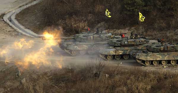South Korea K-1 tanks fire live rounds during air and ground military exercises on the Seungjin Fire Training Field, in mountainous Pocheon December 23, 2010. [Xinhua]