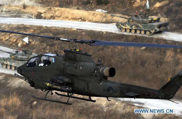 A helicopter and tanks are seen during a military drill in Pocheon, South Korea, on Dec. 23, 2010. South Korea began large-scale drills Thursday involving fighter jets and artillery guns near a heavily fortified land border with the Democratic People&apos;s Republic of Korea (DPRK) amid lingering military tension, the defense ministry said. [Xinhua]