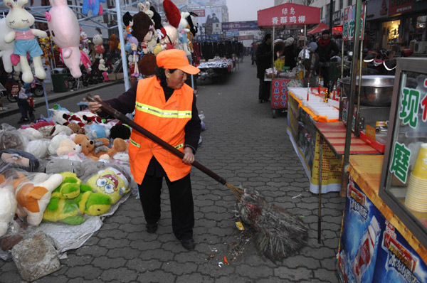 Sanitary worker Li Yukun, 64, sweeps a street in Wendeng city, East China's Shandong province, Dec 22, 2010. [Photo/Xinhua]