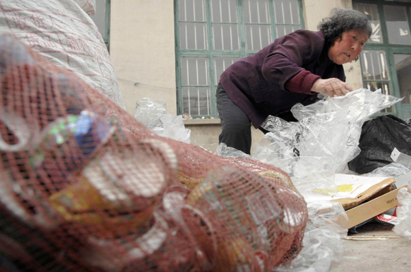 Sanitary worker Li Yukun, 64, sorts her collected garbage at her house in Wendeng city, East China's Shandong province, Dec 23, 2010. [Photo/Xinhua]