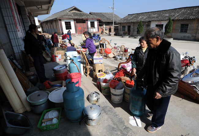 Villagers move everyday items out of their homes in Zhoutian Township, Huichang County in east China&apos;s Jiangxi Province, Dec. 26, 2010. [Xinhua]