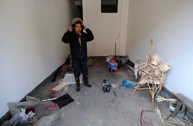 A villager stands in his messy and empty home in Zhoutian Township, Huichang County in east China&apos;s Jiangxi Province, Dec. 26, 2010. 