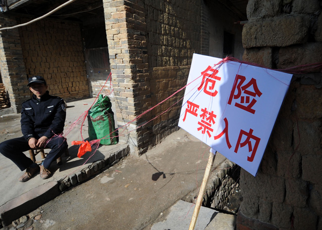 A police officer guards a cordoned-off street in Zhoutian Township, Huichang County in east China&apos;s Jiangxi Province, Dec. 26, 2010. [Xinhua]