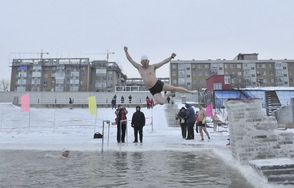 A winter swimmer jumps into the icy water of Songhua River in Harbin, Heilongjiang province Dec 26, 2010. [China Daily/Agencies]