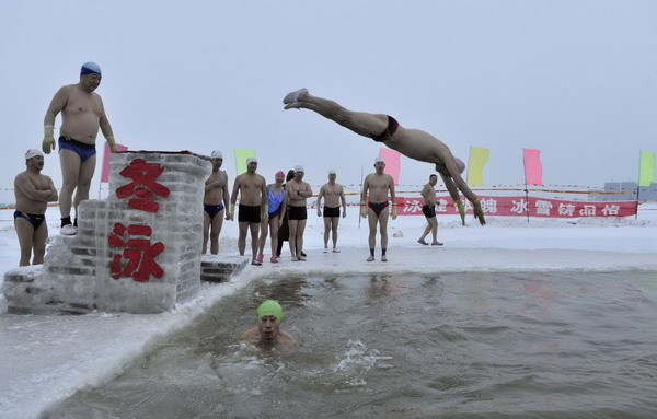 A winter swimmer dives into the icy water of Songhua River in Harbin, Heilongjiang province Dec 26, 2010. [China Daily/Agencies]