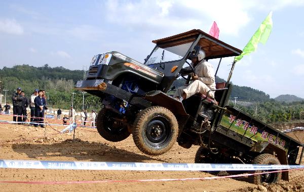 A participant takes part in a tractor race in Qiongzhong, south China&apos;s Hainan Province, Dec. 26, 2010. The first Hainan Tractor Skills Competition kicked off on Sunday, a total of 54 farmers of Hainan took part in the competition.[Xinhua]