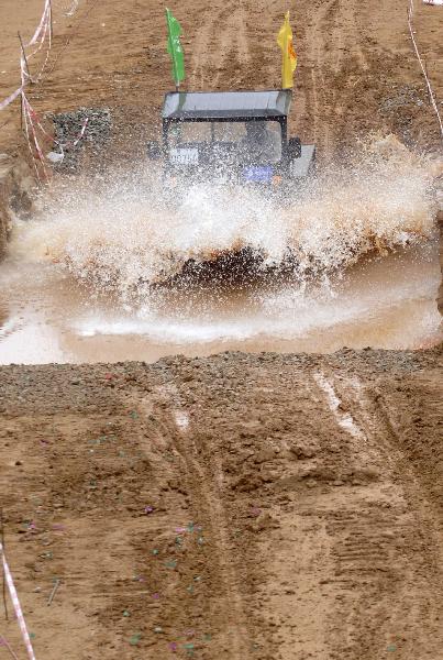 A participant takes part in a tractor race in Qiongzhong, south China&apos;s Hainan Province, Dec. 26, 2010. The first Hainan Tractor Skills Competition kicked off on Sunday, a total of 54 farmers of Hainan took part in the competition.[Xinhua]