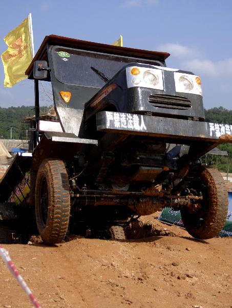 A participant takes part in a tractor race in Qiongzhong, south China&apos;s Hainan Province, Dec. 26, 2010. The first Hainan Tractor Skills Competition kicked off on Sunday, a total of 54 farmers of Hainan took part in the competition.[Xinhua]