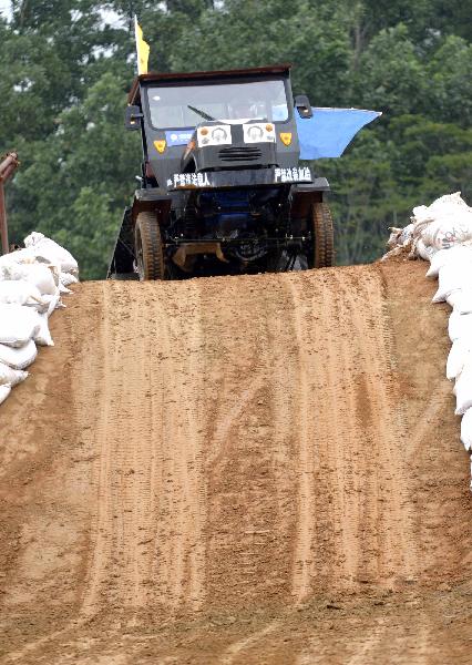 A participant takes part in a tractor race in Qiongzhong, south China&apos;s Hainan Province, Dec. 26, 2010. The first Hainan Tractor Skills Competition kicked off on Sunday, a total of 54 farmers of Hainan took part in the competition.[Xinhua]