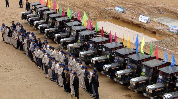 A participant takes part in a tractor race in Qiongzhong, south China&apos;s Hainan Province, Dec. 26, 2010. The first Hainan Tractor Skills Competition kicked off on Sunday, a total of 54 farmers of Hainan took part in the competition.[Xinhua]