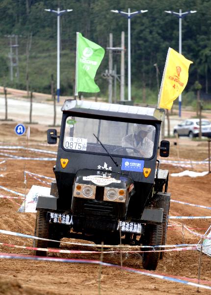 A participant takes part in a tractor race in Qiongzhong, south China&apos;s Hainan Province, Dec. 26, 2010. The first Hainan Tractor Skills Competition kicked off on Sunday, a total of 54 farmers of Hainan took part in the competition.[Xinhua]