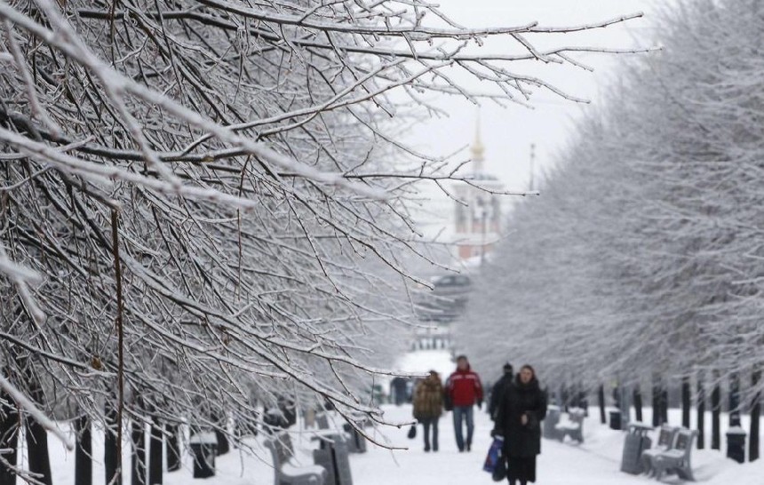 People pass by trees covered with ice in Moscow, Dec 26, 2010. Moscow&apos;s Domodedovo airport was closed and thousands of Muscovites were left without power on Sunday after a heavy overnight snowfall, the RIA Novosti news agency said.[China Daily/Agencies] 