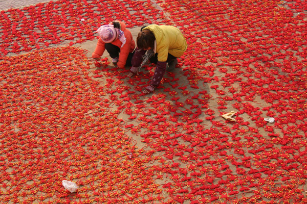 Farmers air materials for making Chinese knots on Sunday in Tancheng county, East China’s Shandong province, in order to meet demand for the Chinese New Year or the Spring Festival, which falls on Feb 3, 2011. [Xinhua]