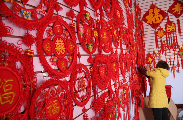 A shop owner sorts Chinese knots for sale on Sunday in Tancheng county, East China’s Shandong province. [Xinhua]