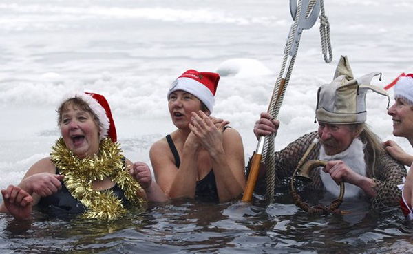 Members of Berlin&apos;s ice swimming club &apos;Berliner Seehunde&apos; (Berlin Seals) take a dip in the Orankesee lake in Berlin as part of their traditional Christmas ice swimming session, December 25, 2010. [Xinhua/Reuters] 