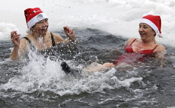 Members of Berlin&apos;s ice swimming club &apos;Berliner Seehunde&apos; (Berlin seals) take a dip in Orankesee lake in Berlin December 25, 2010. Several members of the swimming club met on Saturday for their traditional Christmas ice swimming session. [Xinhua/Reuters] 