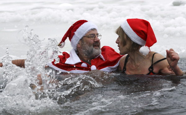 Members of Berlin&apos;s ice swimming club &apos;Berliner Seehunde&apos; (Berlin seals) take a dip in Orankesee lake in Berlin December 25, 2010. Several members of the swimming club met on Saturday for their traditional Christmas ice swimming session. [Xinhua/Reuters] 