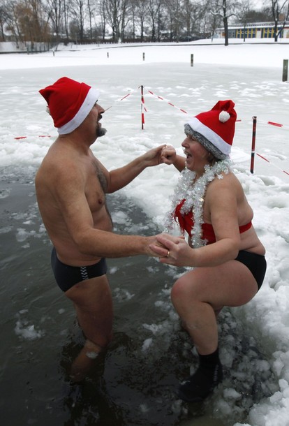 Members of Berlin&apos;s ice swimming club &apos;Berliner Seehunde&apos; (Berlin Seals) take a dip in the Orankesee lake in Berlin as part of their traditional Christmas ice swimming session, December 25, 2010. [Xinhua/Reuters]