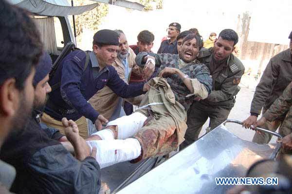 People carry a man injured in the blast to a hospital in northwest Pakistan's Peshawar on December 25, 2010. At least 42 people were killed and 72 others injured in a suicide blast that took place Saturday morning in front of a World Food Program office in Pakistan's northwest city of Khar in Bajaur Agency. [Saeed Ahmad]