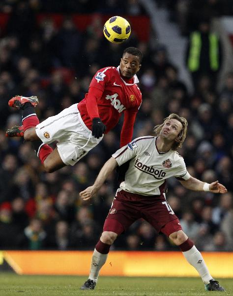 Sunderland's Boudewijn Zenden (R) challenges Manchester United's Patrice Evra during their English Premier League soccer match at Old Trafford in Manchester, northern England December 26, 2010. (Xinhua/Reuters Photo)