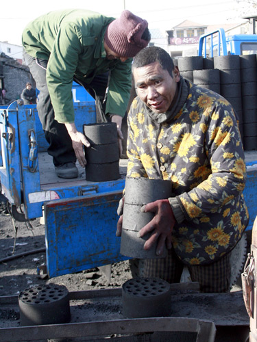 Laborers work at a briquette factory on Huashan West Road in Jinan, capital of Shandong province, on Dec 15. The factory reportedly employs four mentally disabled workers.