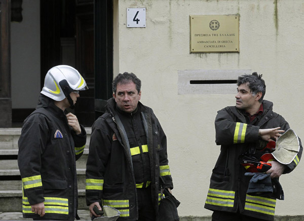 Fire-fighters talk as they leave the Greek embassy in Rome December 27, 2010. [China Daily/Agencies] 