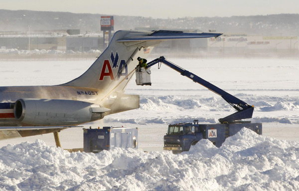 A worker de-ices the tail fin of an airplane at Newark Liberty International Airport in New Jersey Dec 27, 2010. [China Daily/Agencies] 