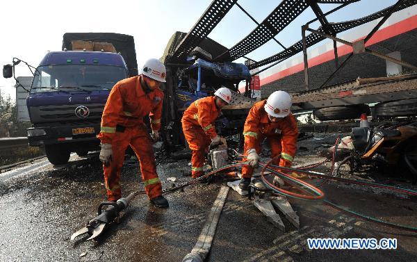 Rescuers work at the accident locale after heavy fog caused an car accident on the express way connecting Guiyang and Zunyi in southwest China&apos;s Guizhou Province, Dec. 27, 2010. A chain of rear-end collisions began after a heavy truck crashed into a petrol station at about 8 a.m. on Monday. At least 7 people were killed and 15 were injured in the accident. [Xinhua]