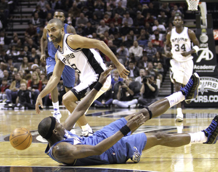 San Antonio Spurs' Tony Parker works the ball around Washington Wizards' Josh Howard, who falls to the floor, during the first quarter of their NBA game in San Antonio on Sunday. The Spurs won 94-80.